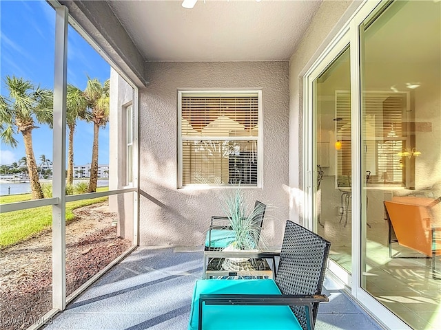 sunroom featuring a water view