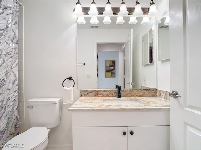 bathroom with vanity, toilet, and walk in shower