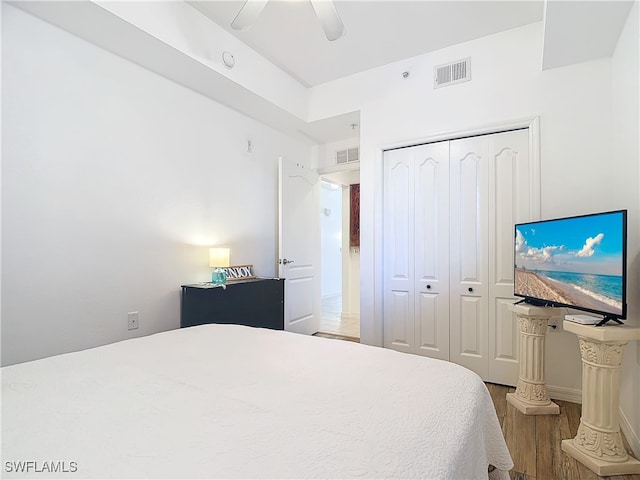 bedroom with ceiling fan, a closet, and wood-type flooring