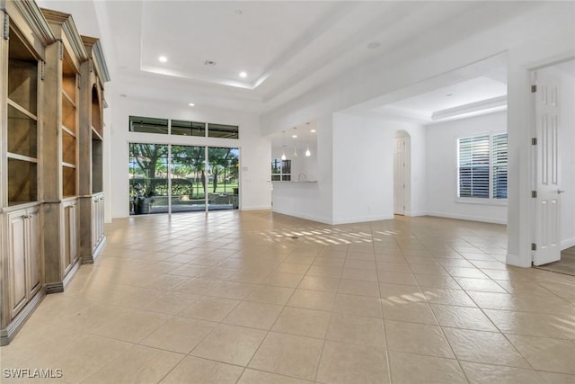 unfurnished living room with light tile patterned floors, a raised ceiling, and recessed lighting