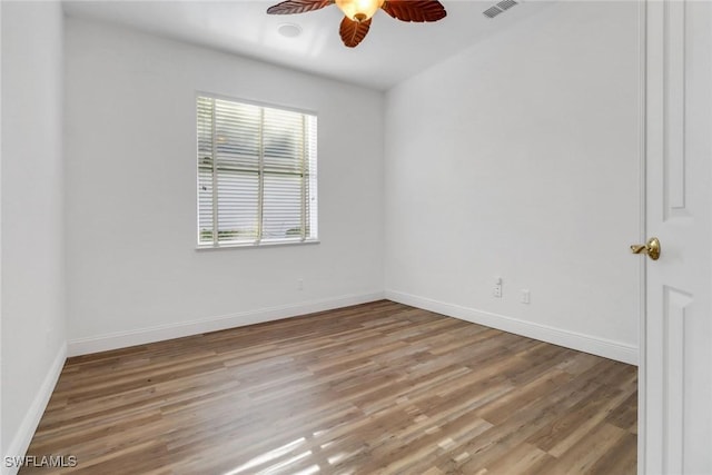 spare room with visible vents, light wood-type flooring, baseboards, and ceiling fan