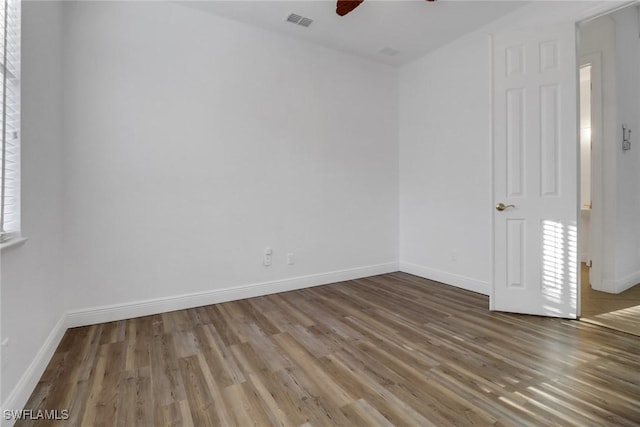 spare room featuring visible vents, baseboards, a ceiling fan, and wood finished floors