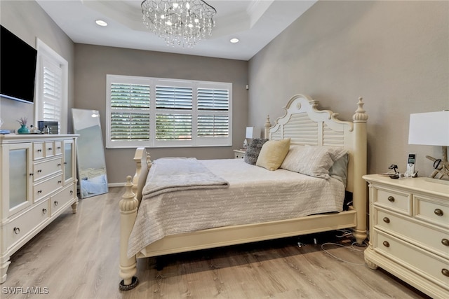 bedroom with a chandelier and light hardwood / wood-style floors