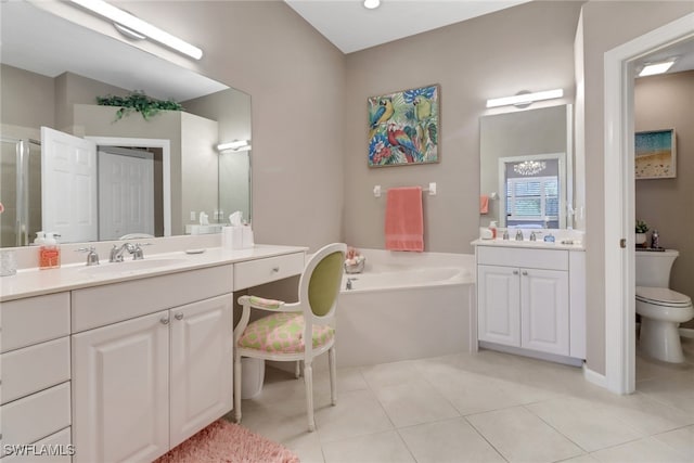 bathroom with toilet, vanity, tile patterned floors, and a tub