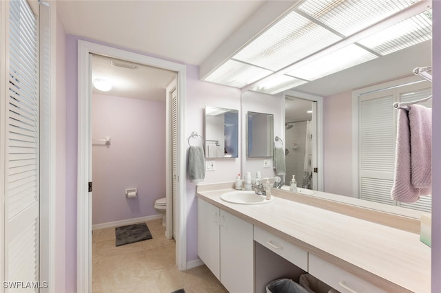 bathroom featuring a shower, tile patterned floors, vanity, and toilet