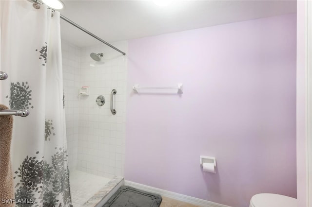 bathroom with curtained shower and toilet