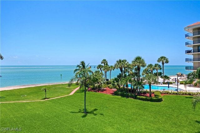 view of home's community with a view of the beach, a swimming pool, a water view, and a lawn