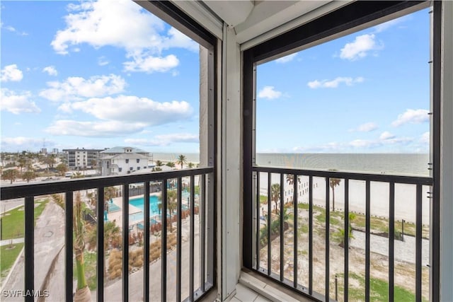 balcony with a water view and a beach view