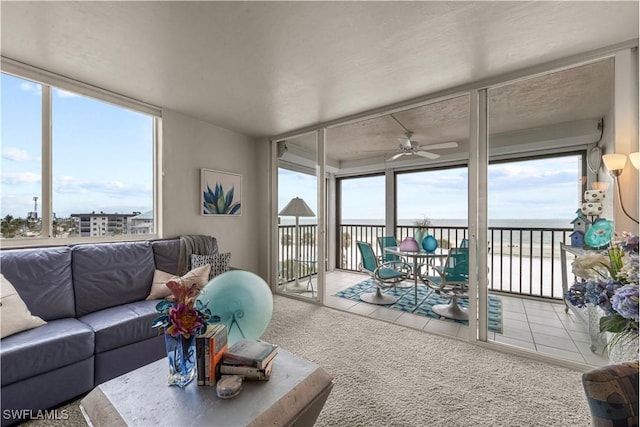 sunroom / solarium featuring a water view and ceiling fan