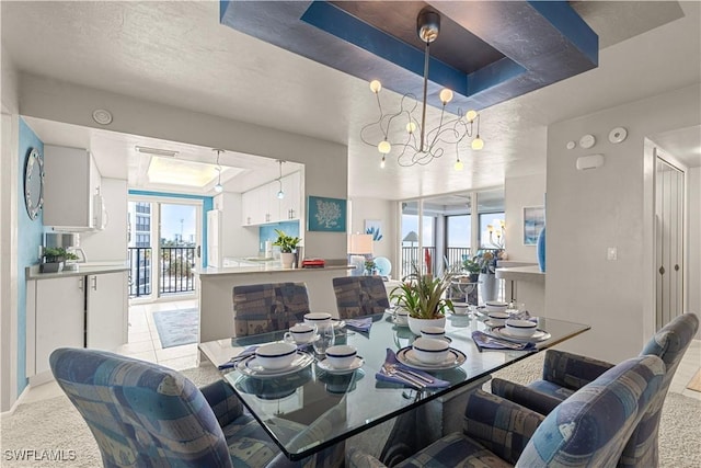 dining room featuring a raised ceiling, a textured ceiling, and a notable chandelier