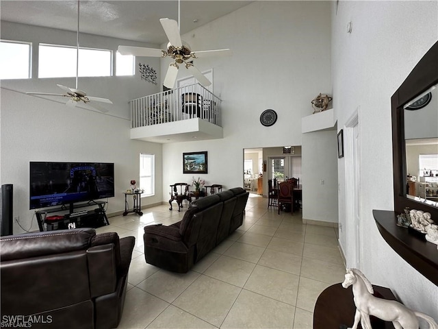 tiled living room with ceiling fan and high vaulted ceiling