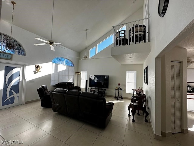 living room featuring tile patterned floors, ceiling fan, and high vaulted ceiling