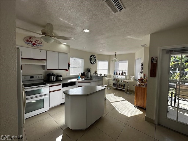 kitchen featuring white cabinets, pendant lighting, electric range, and plenty of natural light