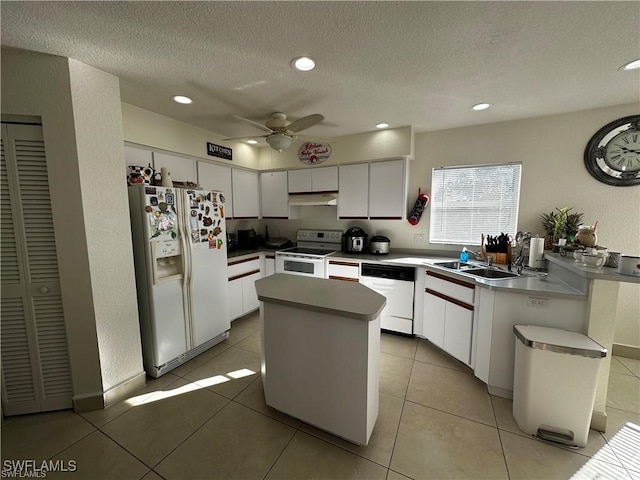 kitchen featuring white appliances, a kitchen island, ceiling fan, sink, and white cabinetry