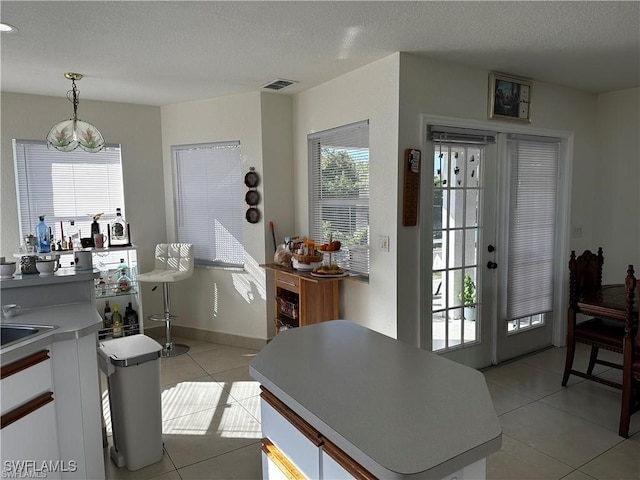 interior space featuring a textured ceiling and light tile patterned flooring