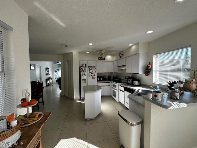 kitchen featuring white cabinetry, sink, ceiling fan, a textured ceiling, and white appliances