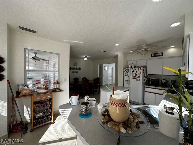 dining area featuring ceiling fan and a textured ceiling