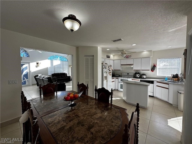 dining room with light tile patterned floors, a textured ceiling, and ceiling fan