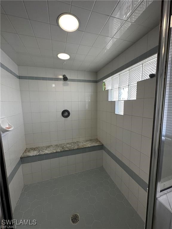 bathroom with tile patterned floors and a tile shower