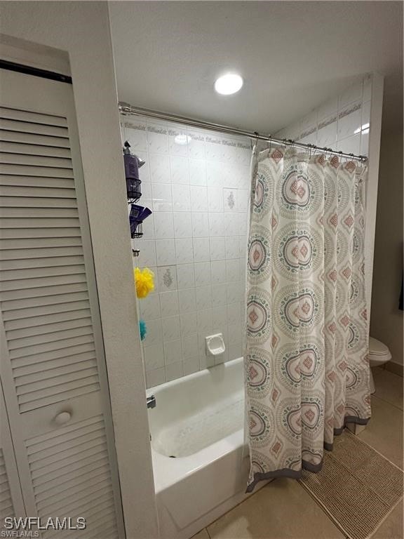 bathroom featuring tile patterned floors, toilet, and shower / tub combo