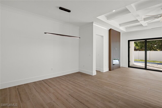 empty room featuring light wood-style floors, baseboards, coffered ceiling, and a ceiling fan