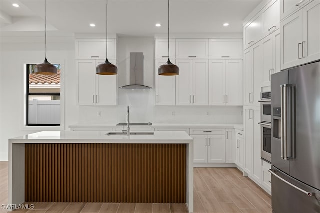 kitchen featuring pendant lighting, white cabinetry, stainless steel appliances, and an island with sink