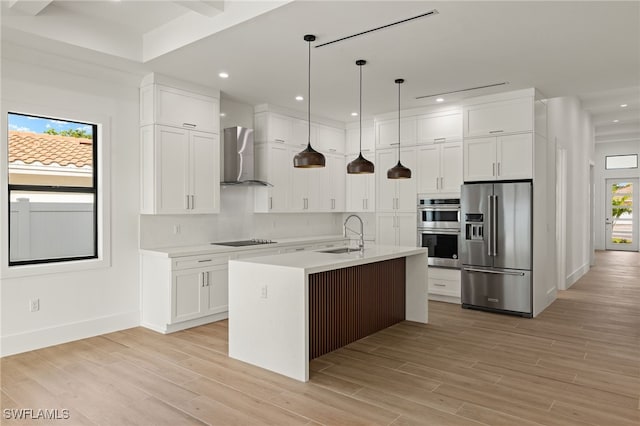 kitchen featuring stainless steel appliances, a sink, light countertops, wall chimney exhaust hood, and an island with sink