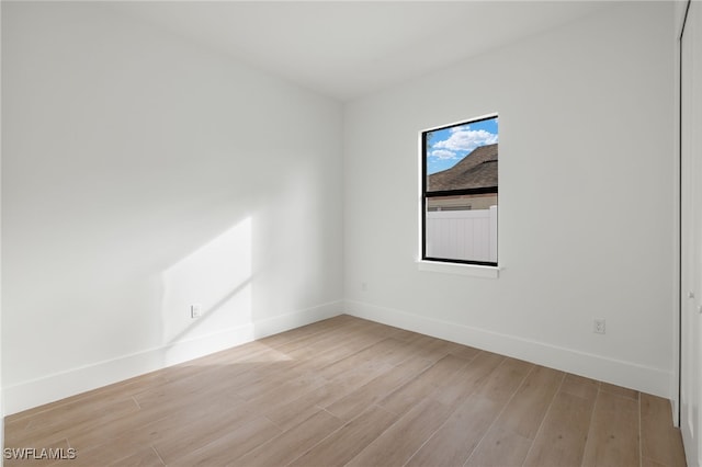 empty room featuring light wood-style floors and baseboards