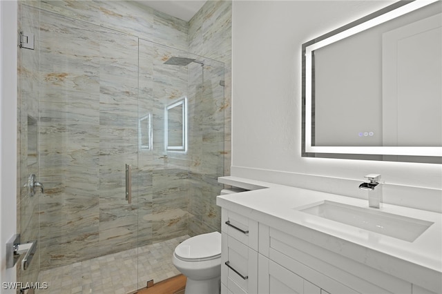 bathroom with toilet, a shower stall, and vanity