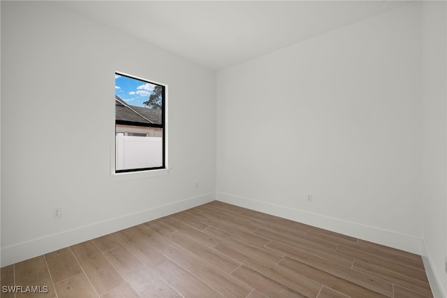 empty room with light wood finished floors and baseboards