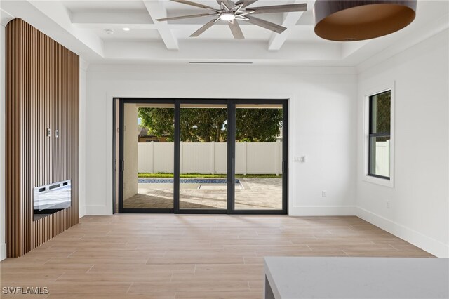 empty room featuring beamed ceiling, ceiling fan, light wood-type flooring, and coffered ceiling