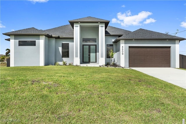 prairie-style house featuring a garage, french doors, and a front lawn