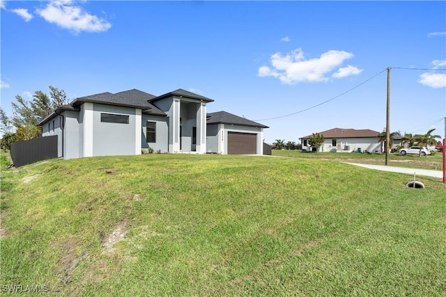 view of front of house with a front yard and a garage