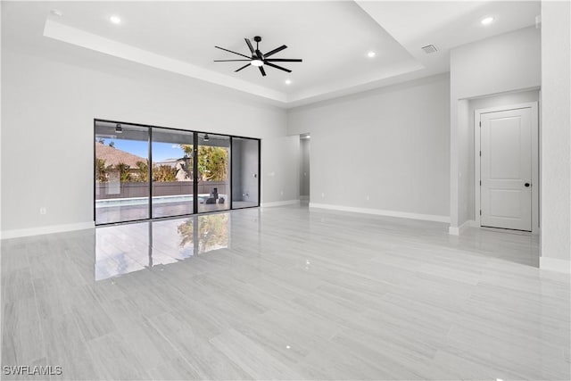 spare room with a tray ceiling and ceiling fan