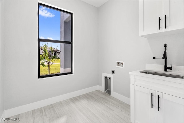 washroom featuring hookup for an electric dryer, washer hookup, cabinets, and sink