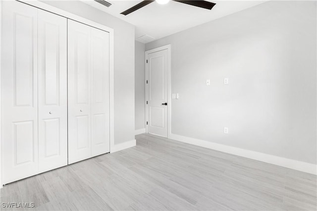 unfurnished bedroom with a closet, light hardwood / wood-style flooring, and ceiling fan