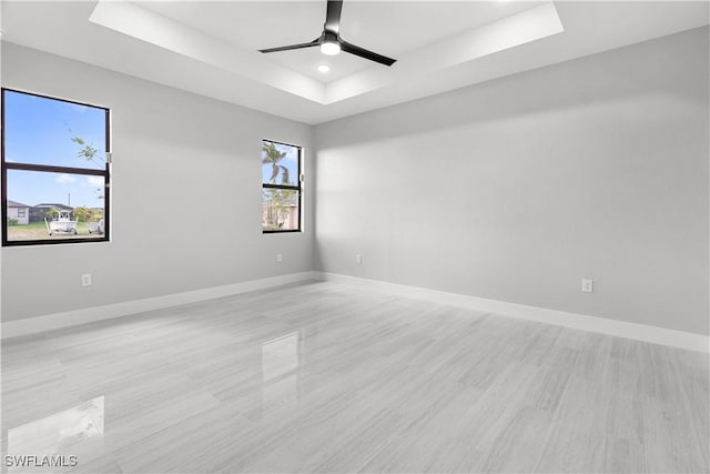 empty room with a tray ceiling and ceiling fan