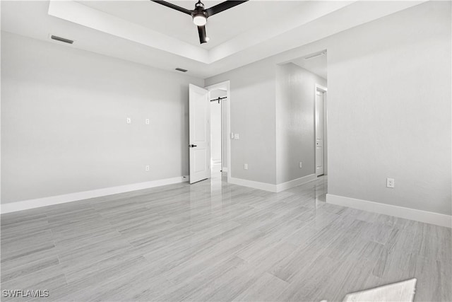 unfurnished room with a tray ceiling and ceiling fan