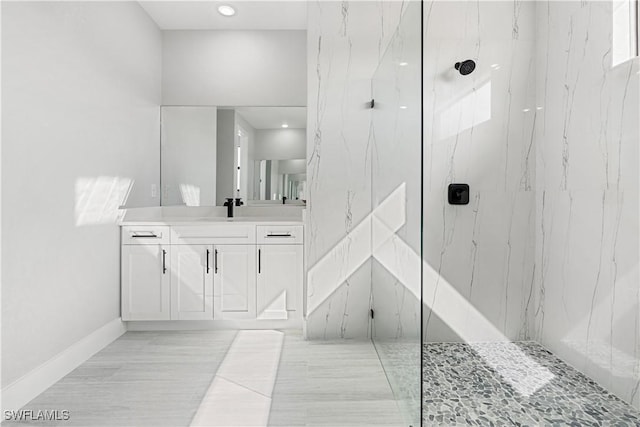 bathroom featuring a tile shower and vanity