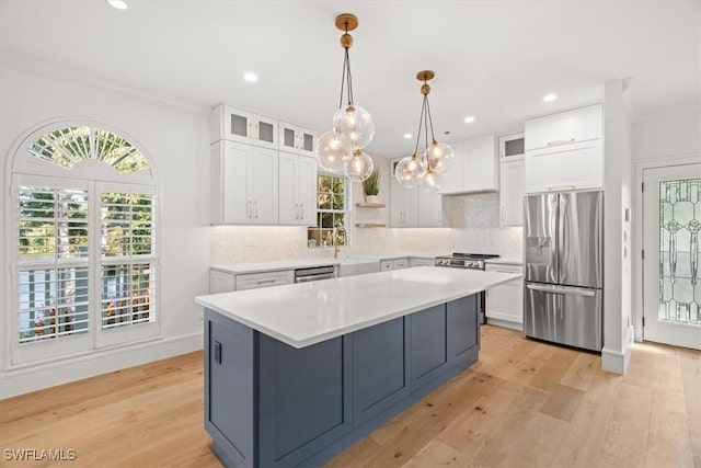 kitchen with appliances with stainless steel finishes, white cabinets, tasteful backsplash, ornamental molding, and recessed lighting