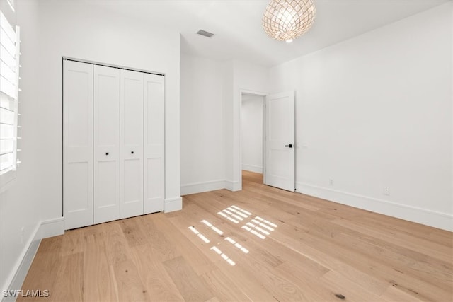 unfurnished bedroom featuring light hardwood / wood-style floors and a closet