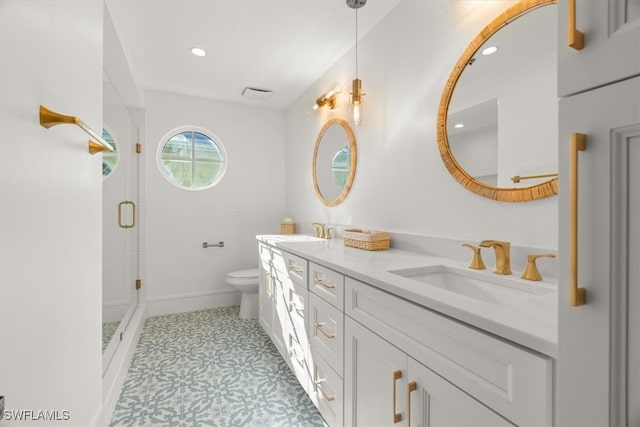 bathroom featuring tile patterned flooring, toilet, vanity, and walk in shower