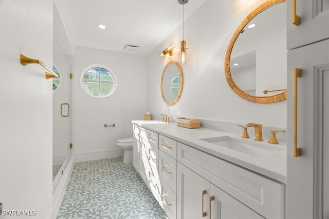 full bath with toilet, a shower stall, double vanity, recessed lighting, and baseboards