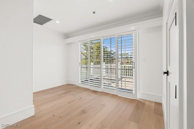 unfurnished room with crown molding, light wood finished floors, baseboards, and a pendent fire sprinkler