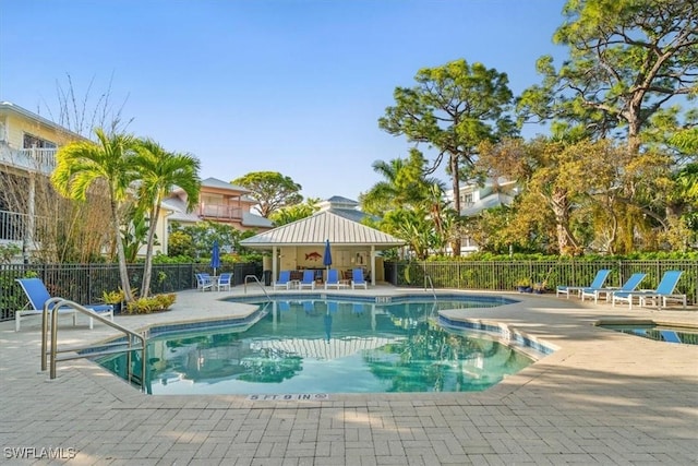 community pool with fence and a patio area