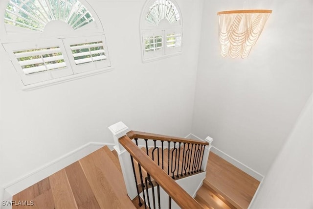 stairs with wood finished floors and baseboards