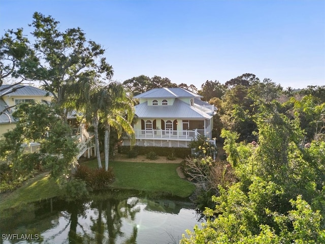 exterior space featuring a lawn and a water view