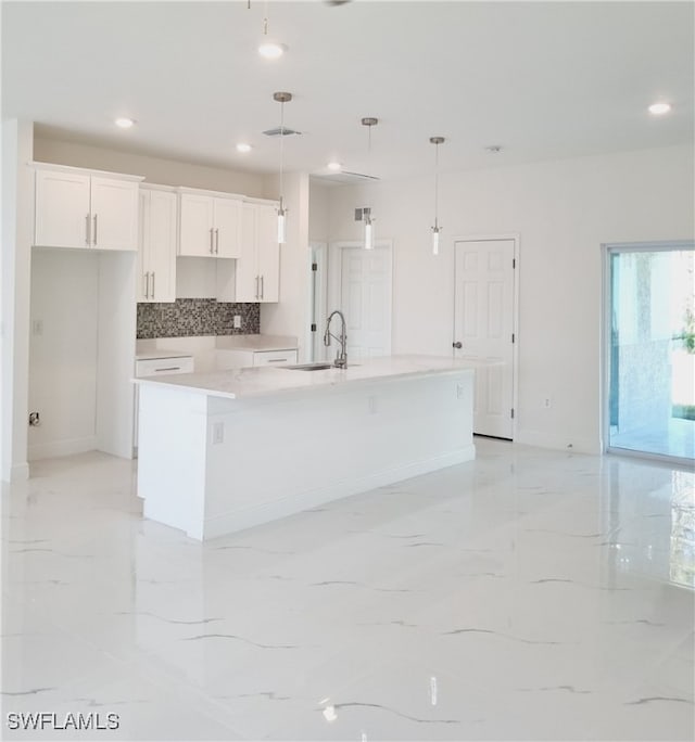 kitchen featuring a large island, white cabinets, and hanging light fixtures