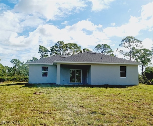 rear view of property featuring a lawn