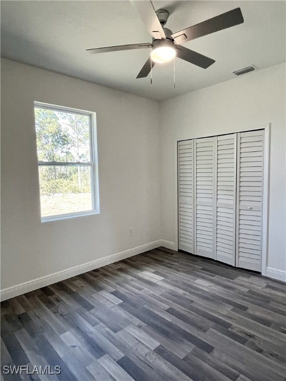 unfurnished bedroom with a closet, ceiling fan, and dark hardwood / wood-style flooring